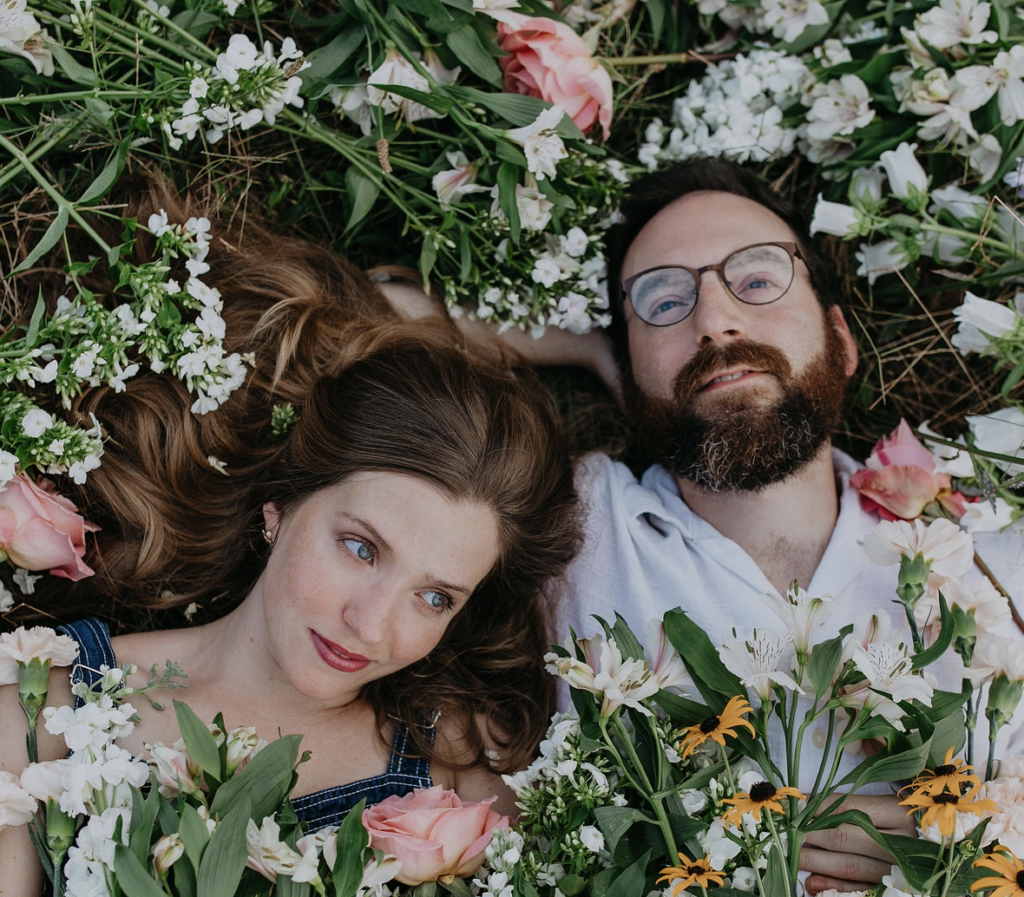 Becca and Coty of Admiral Radio in a bed of flowers.